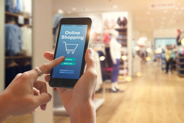 Smart phone online shopping in woman hand. Network connection on mobile screen. Payments online. Shopping mall department store background